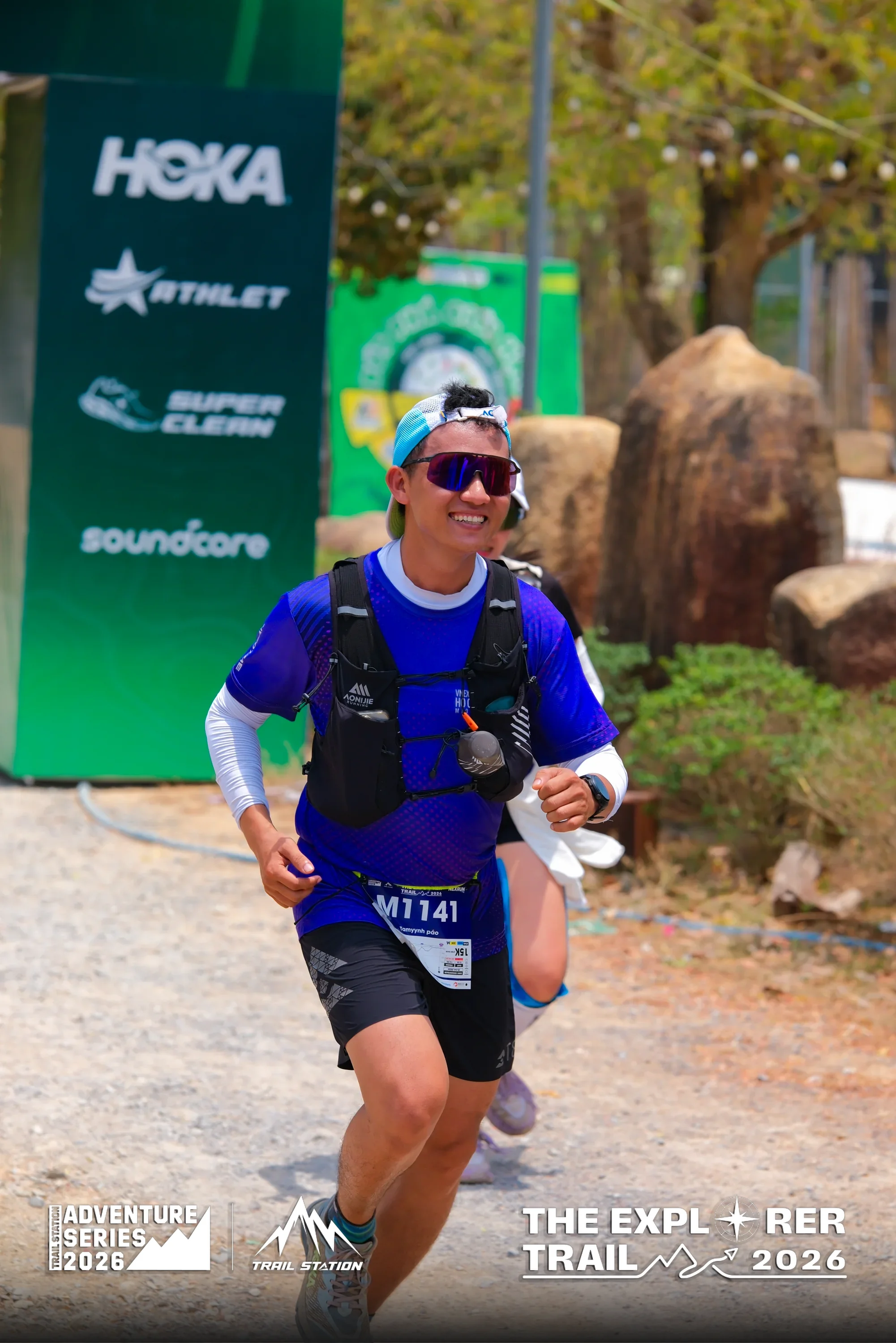 Smiling runner approaching The Explorer Trail finish line