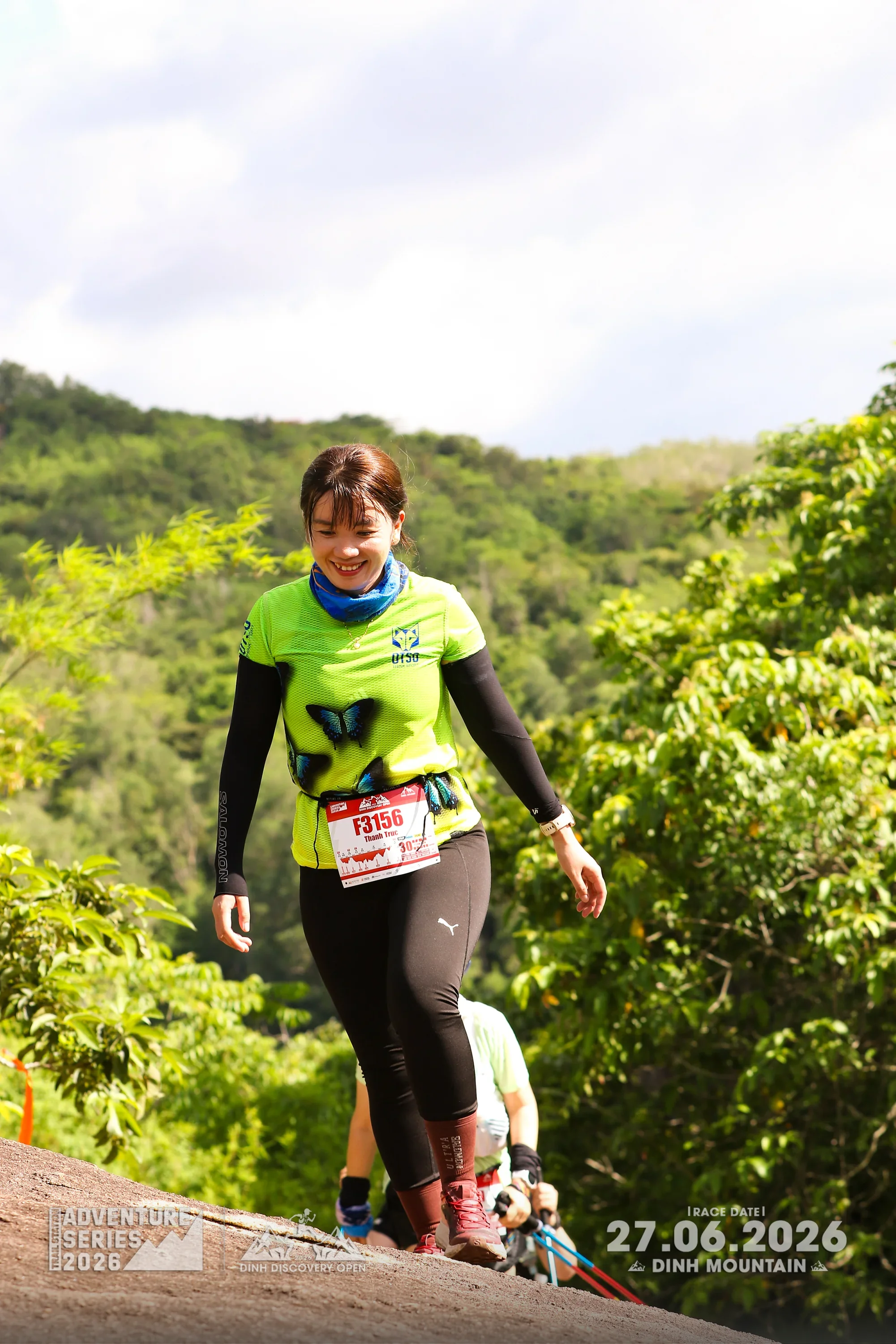 Runner smiling while descending the Dinh Discovery Open trail